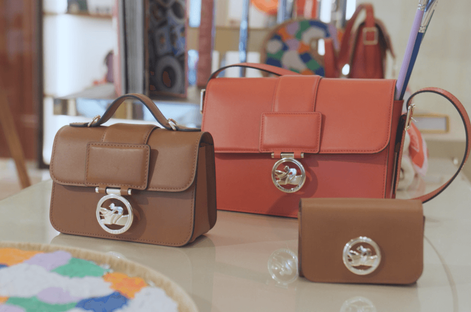 Three Longchamp bags are displaying in the boutique 